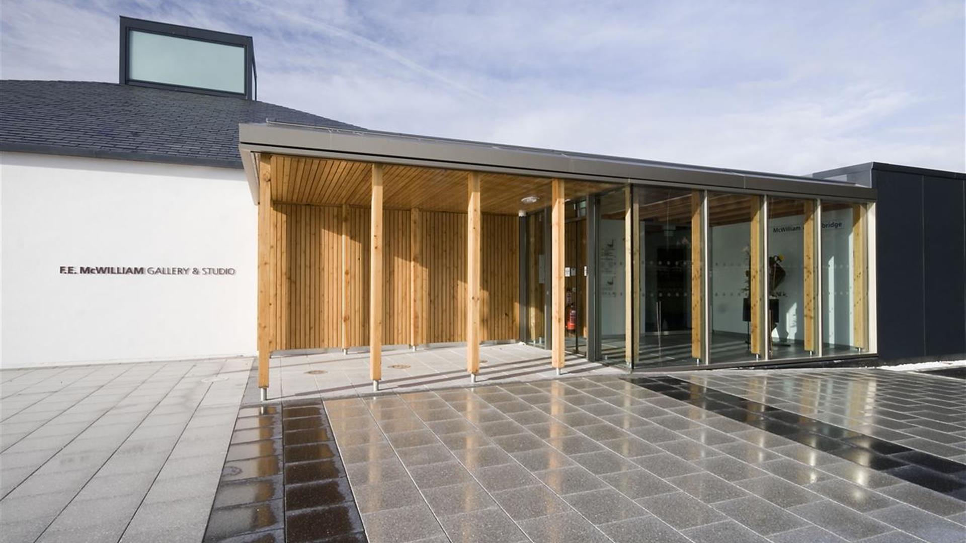 The modern and glass-fronted F.E. McWilliam Gallery and Studio in Banbridge, Northern Ireland, under a sunny sky.