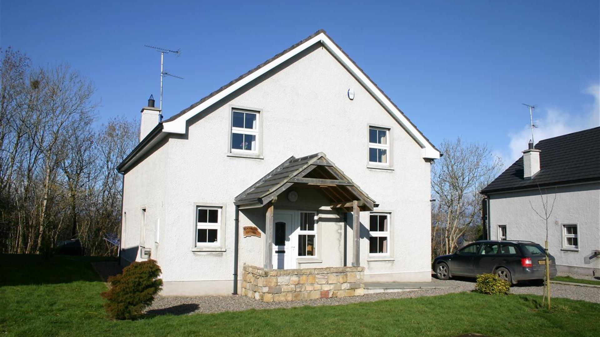 Large white two store house with stone porch feature