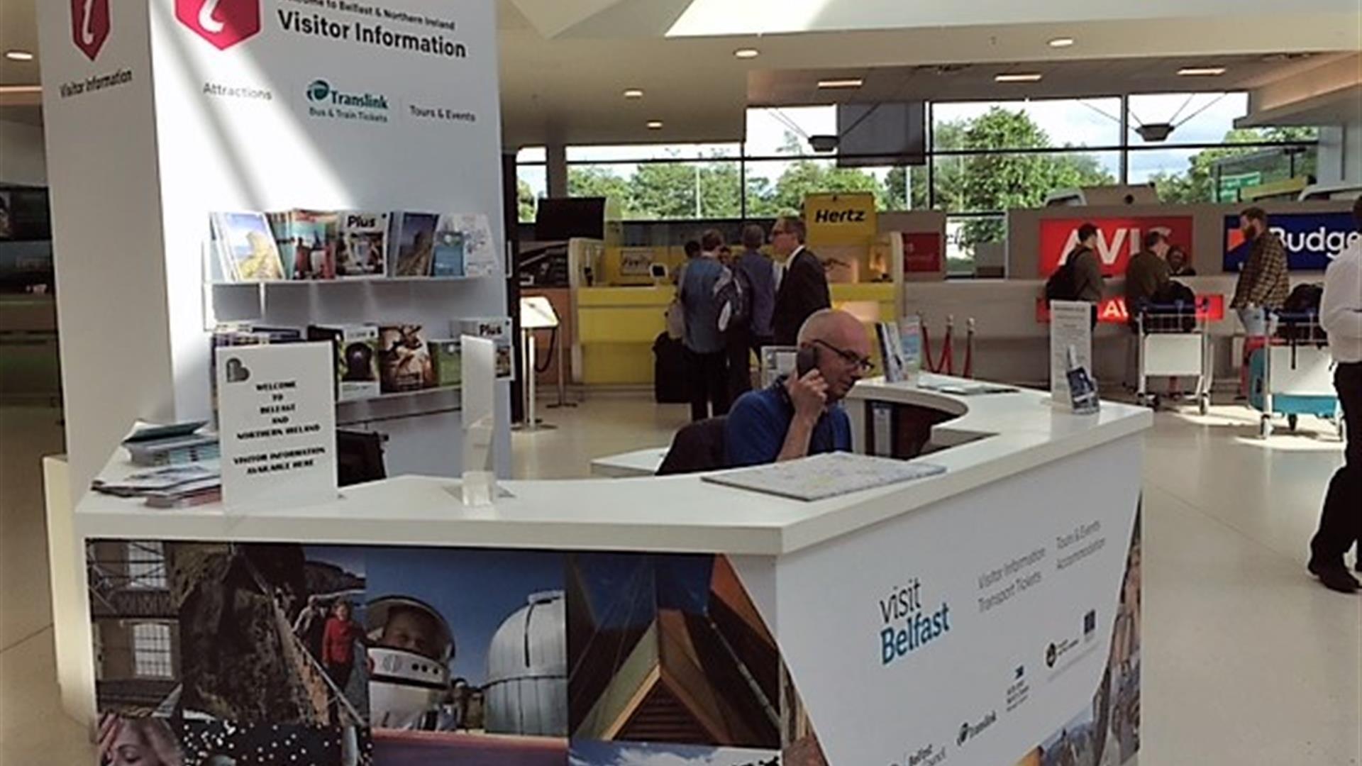 Receptionist on the phone at the visitor information kiosk.