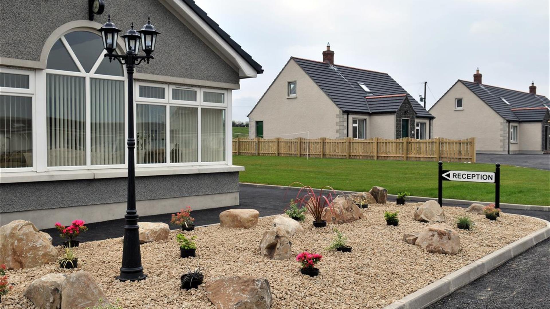 Image shows front of one of the cottages and Reception sign