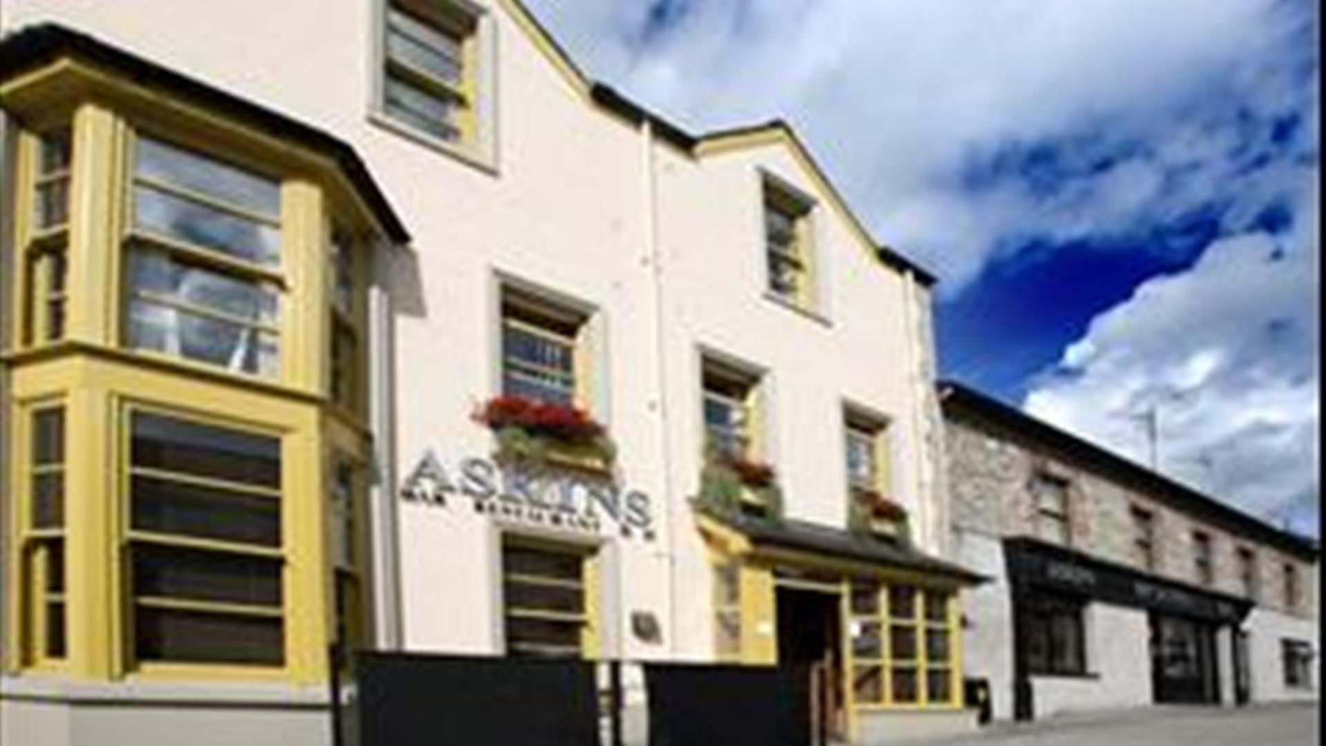 Outside image of The Tailor's house with yellow window frames and black door