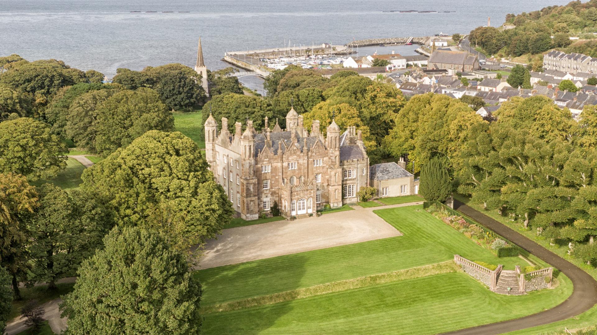 Aerial view of Glenarm Castle & Gardens with the ocean beyond.