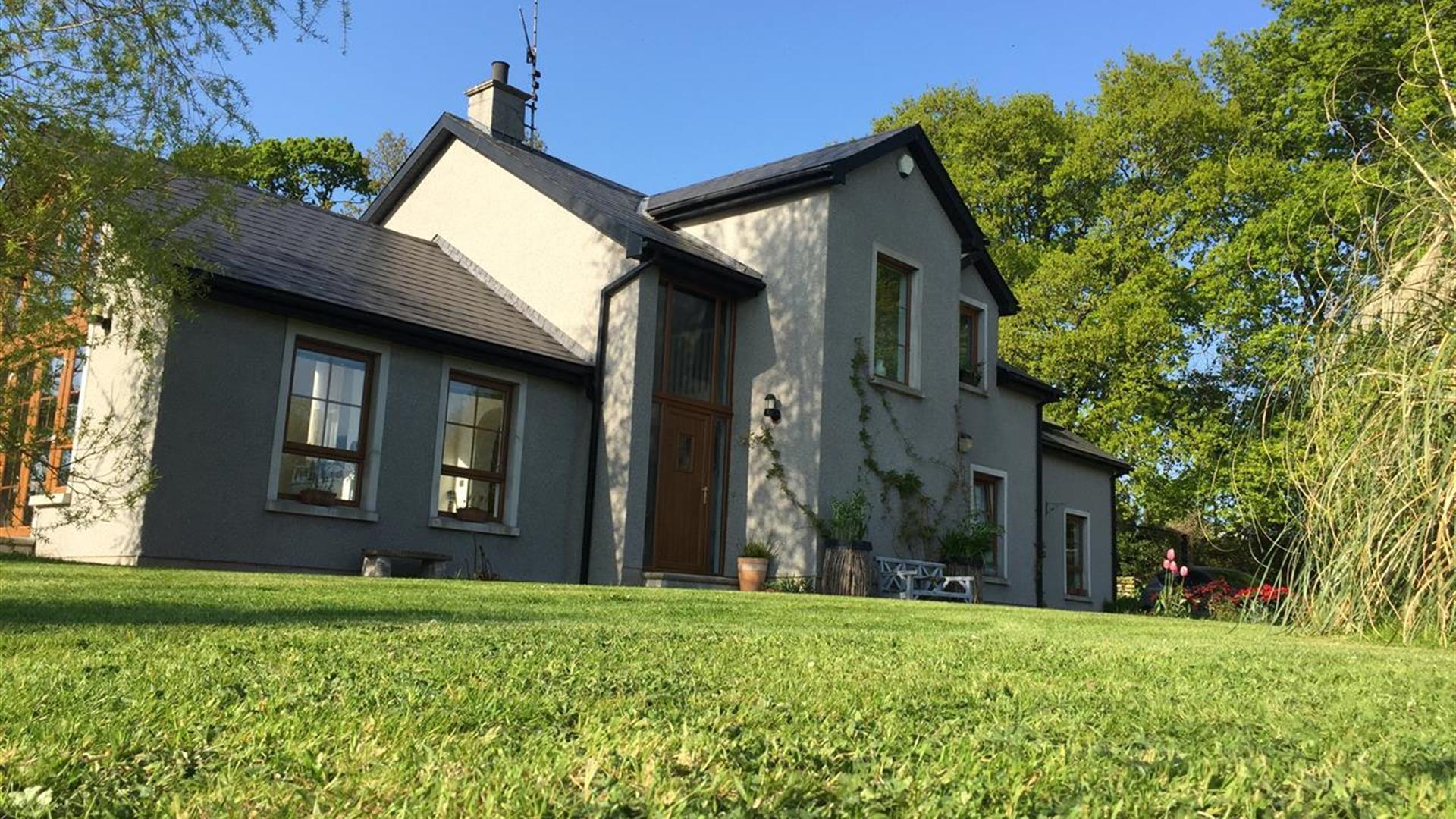 Image shows front entrance of the property with lawn at the front