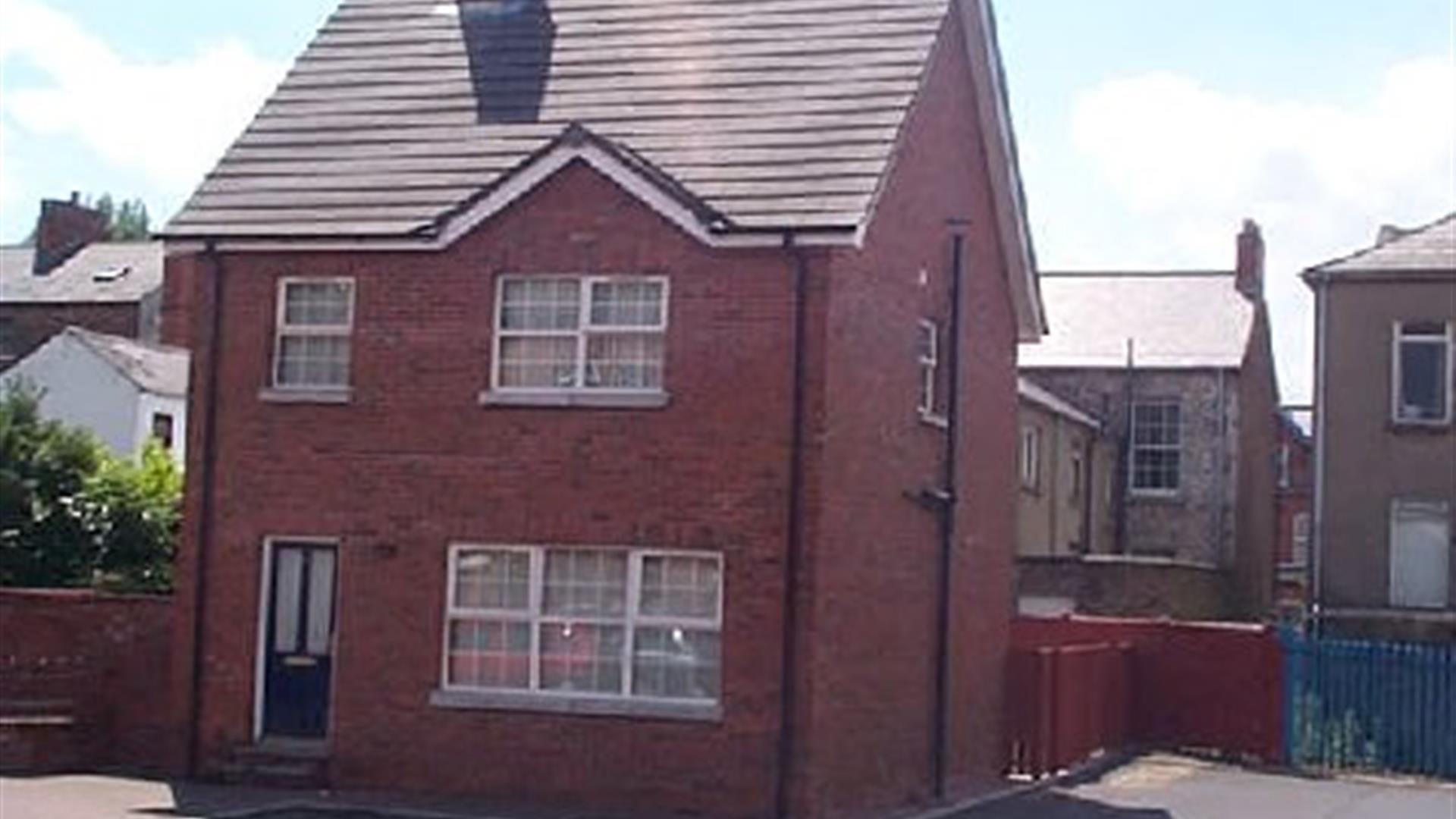 A photo of a dethatched red brick house.