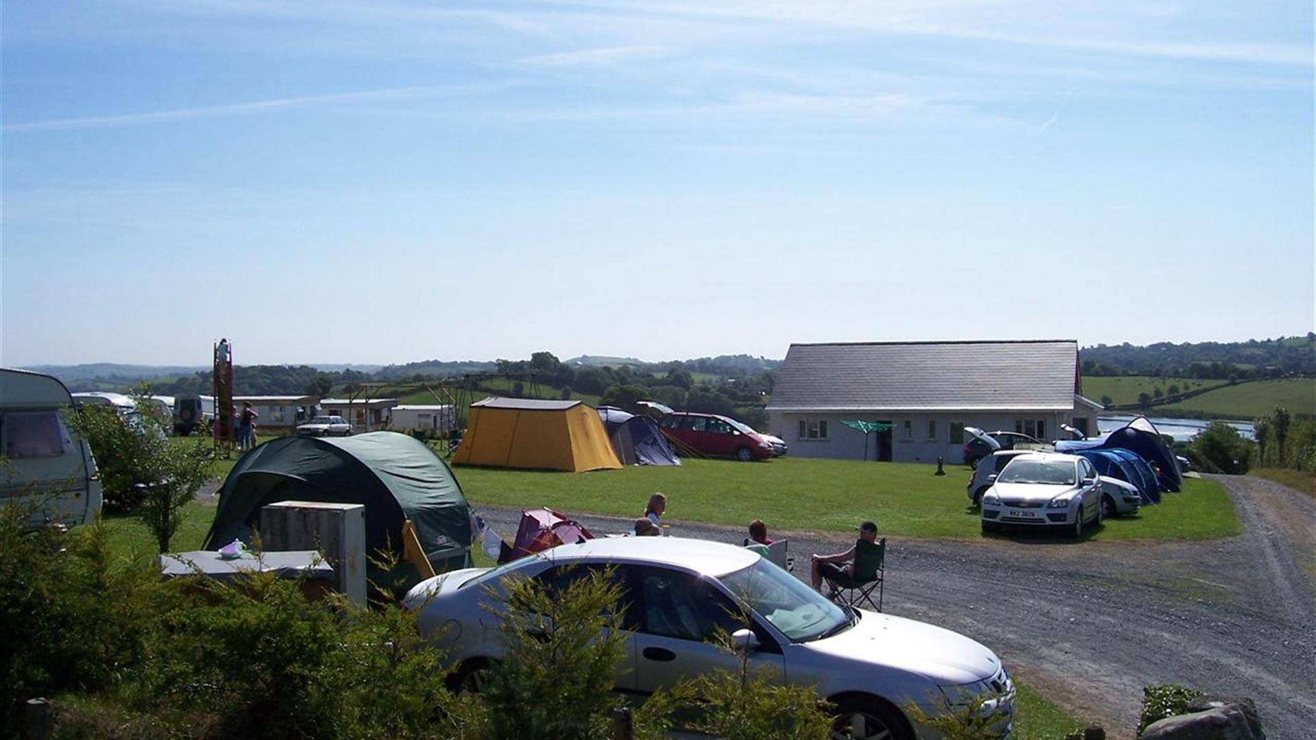 Image is of campsite with people sitting around