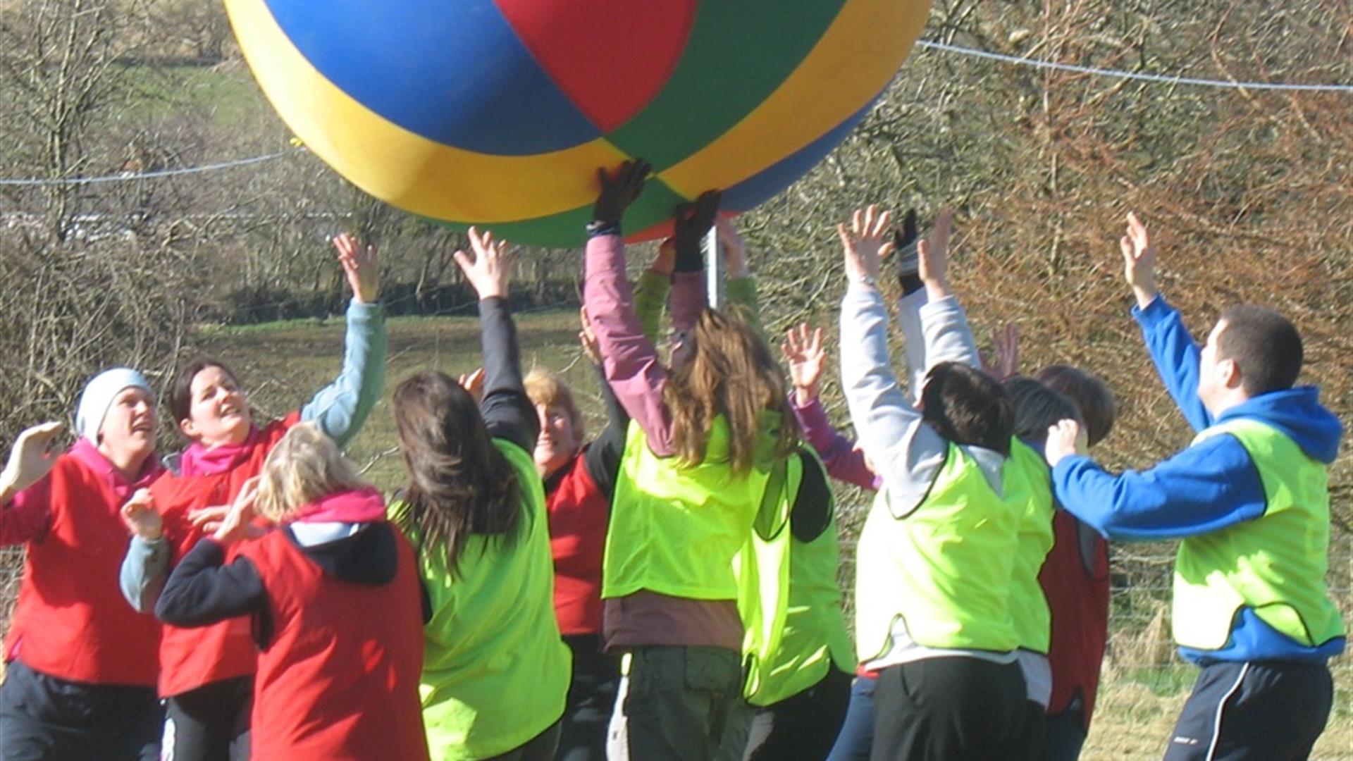 People playing a game with a large beach ball.