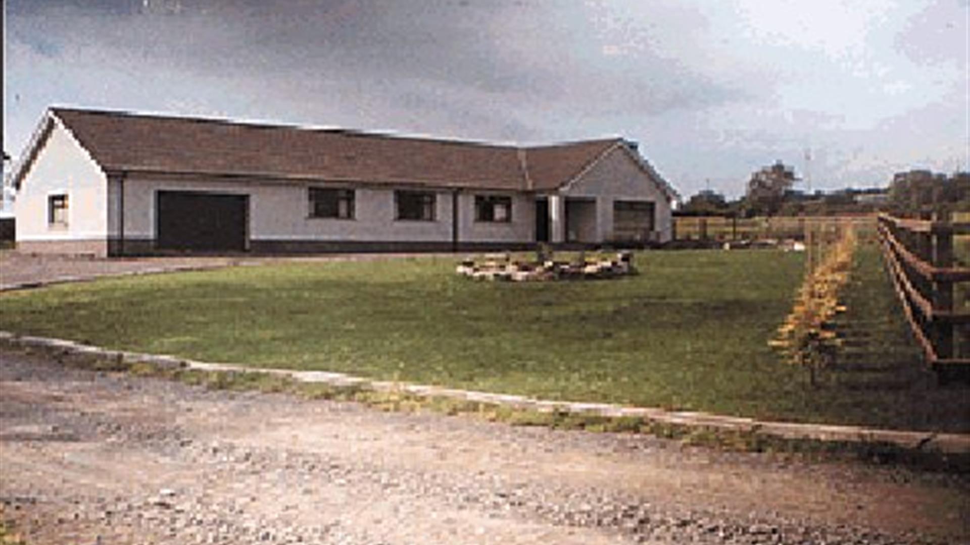 Driveway of a country Bungalow BnB with a large front lawn.