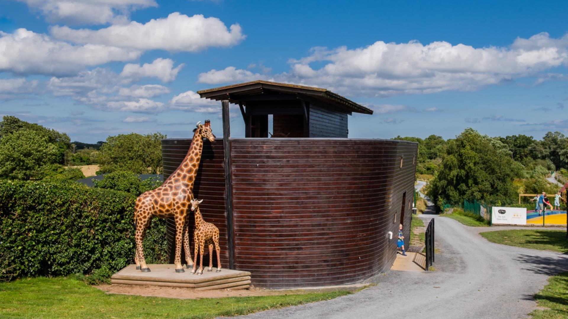 Image of the Ark Open Farm's small replica of Noah's Ark with animal statues including giraffe