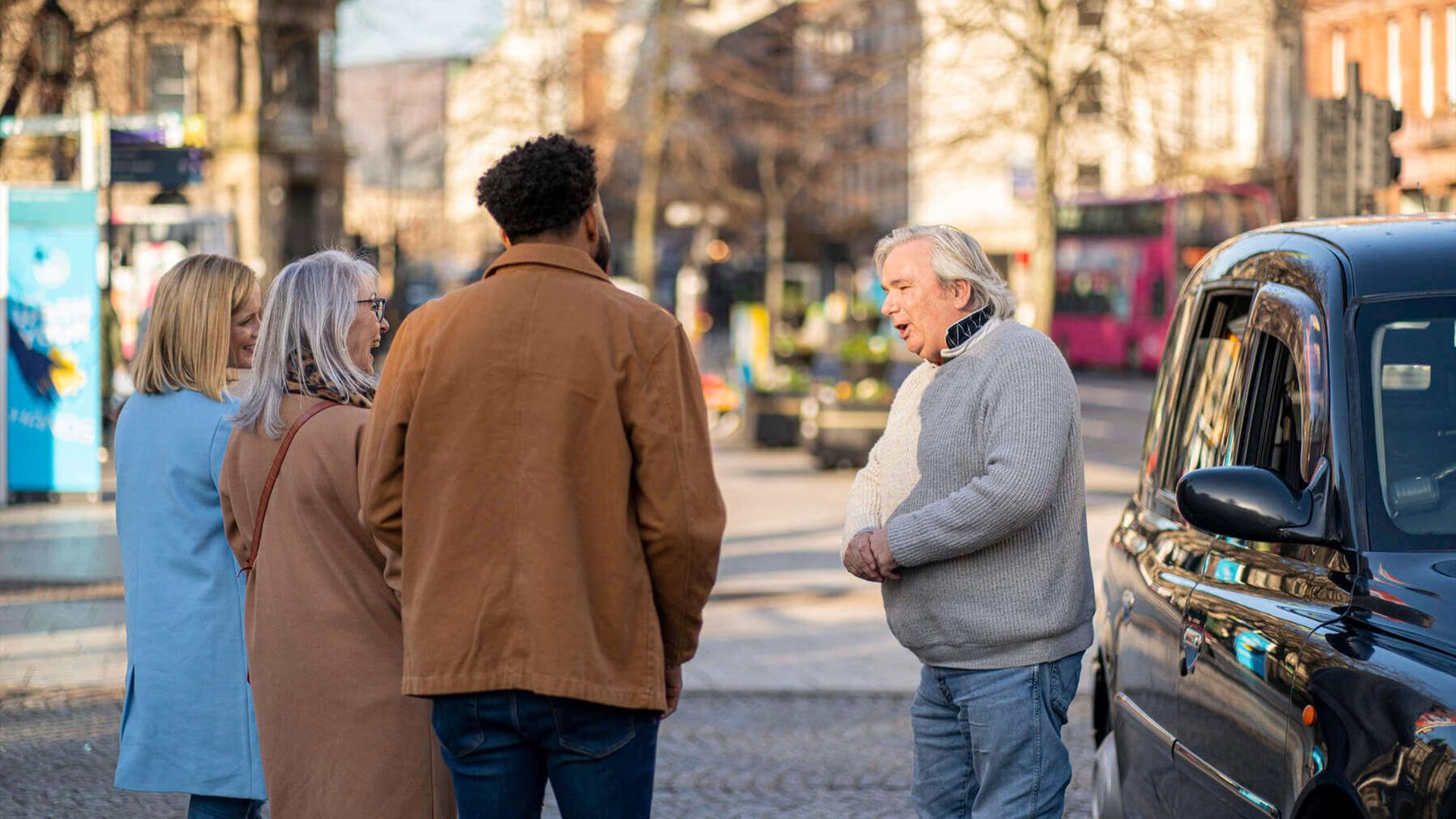 Billy Scott greets his tour group for the Belfast Black Cab Tour