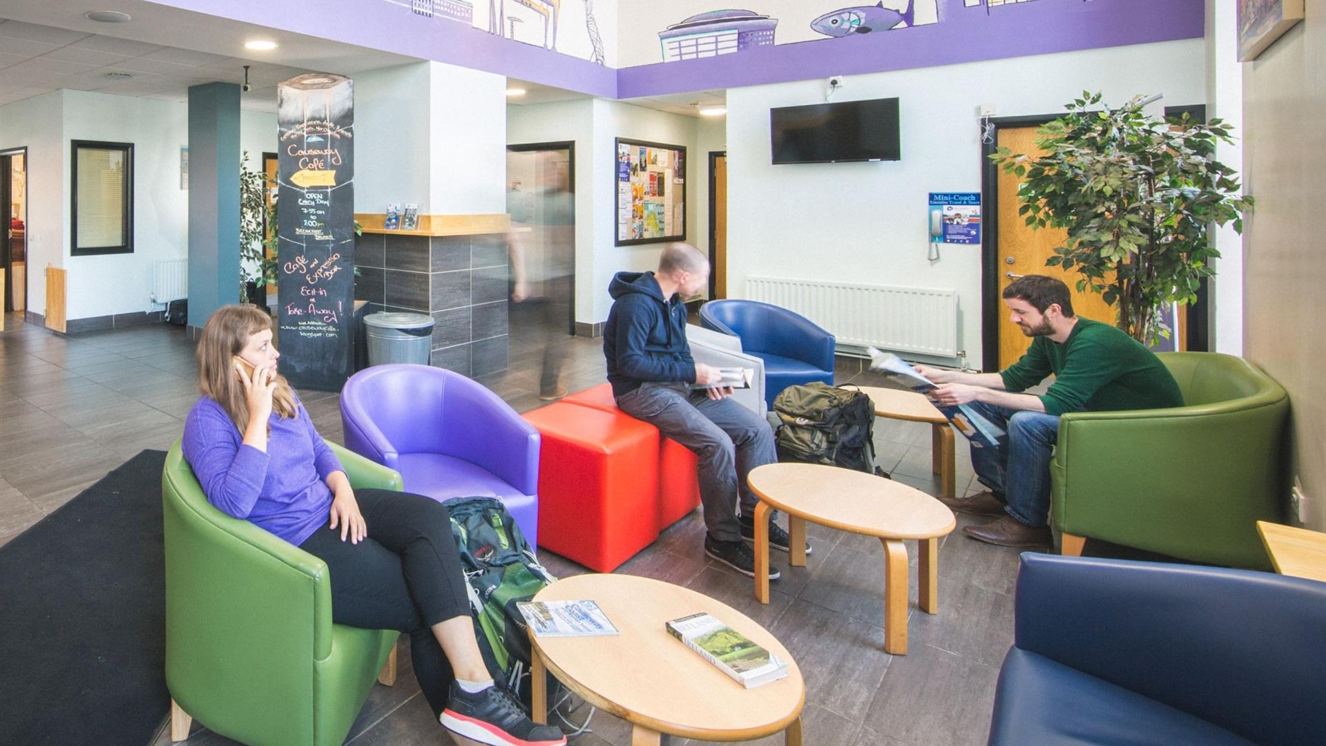 A photo of a communal lobby area with a group of people sitting together.