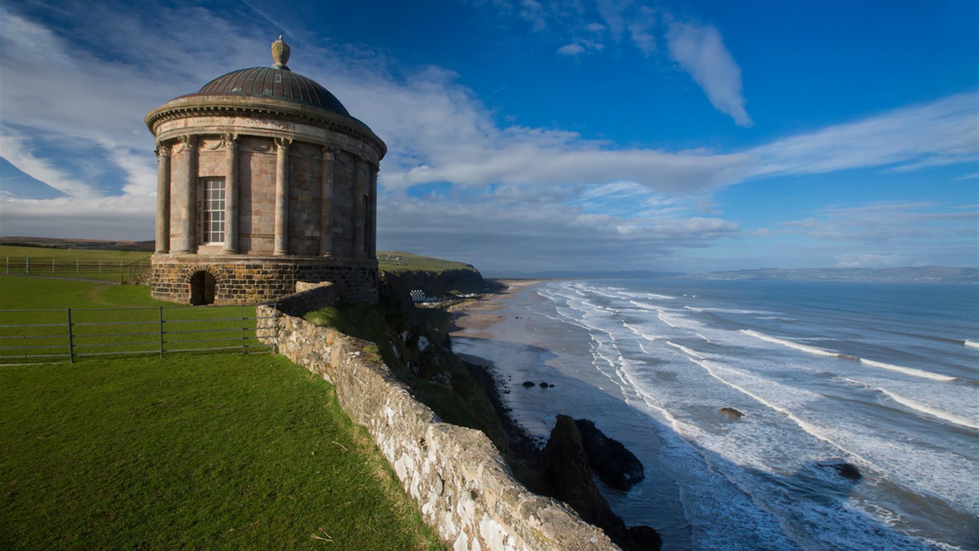Mussenden Temple, a small circular classical building perched dramatically on a cliff edge overlooking Downhill Beach and the Atlantic Ocean, near Coleraine, Northern Ireland.