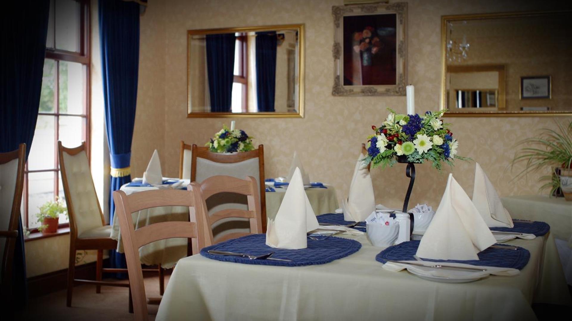 Image shows breakfast room with tables and chairs