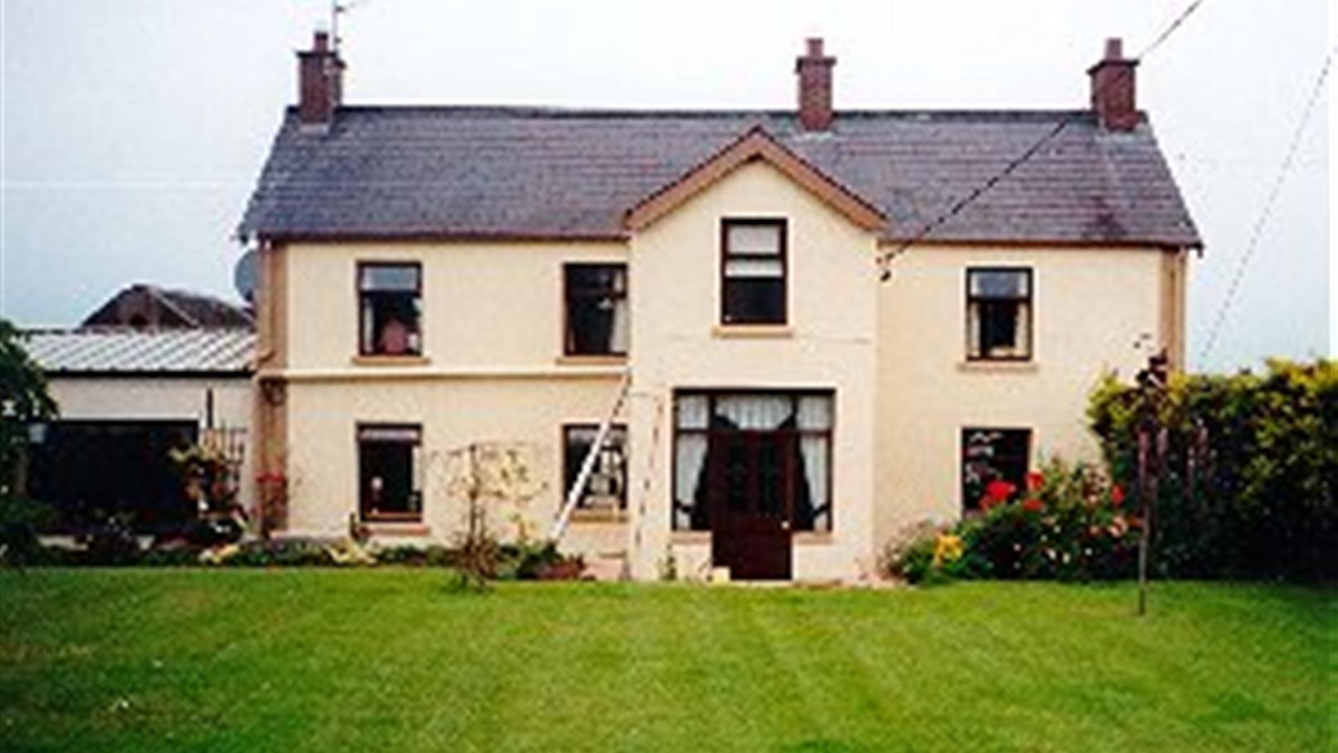 A large two-story lodge with a lawn.