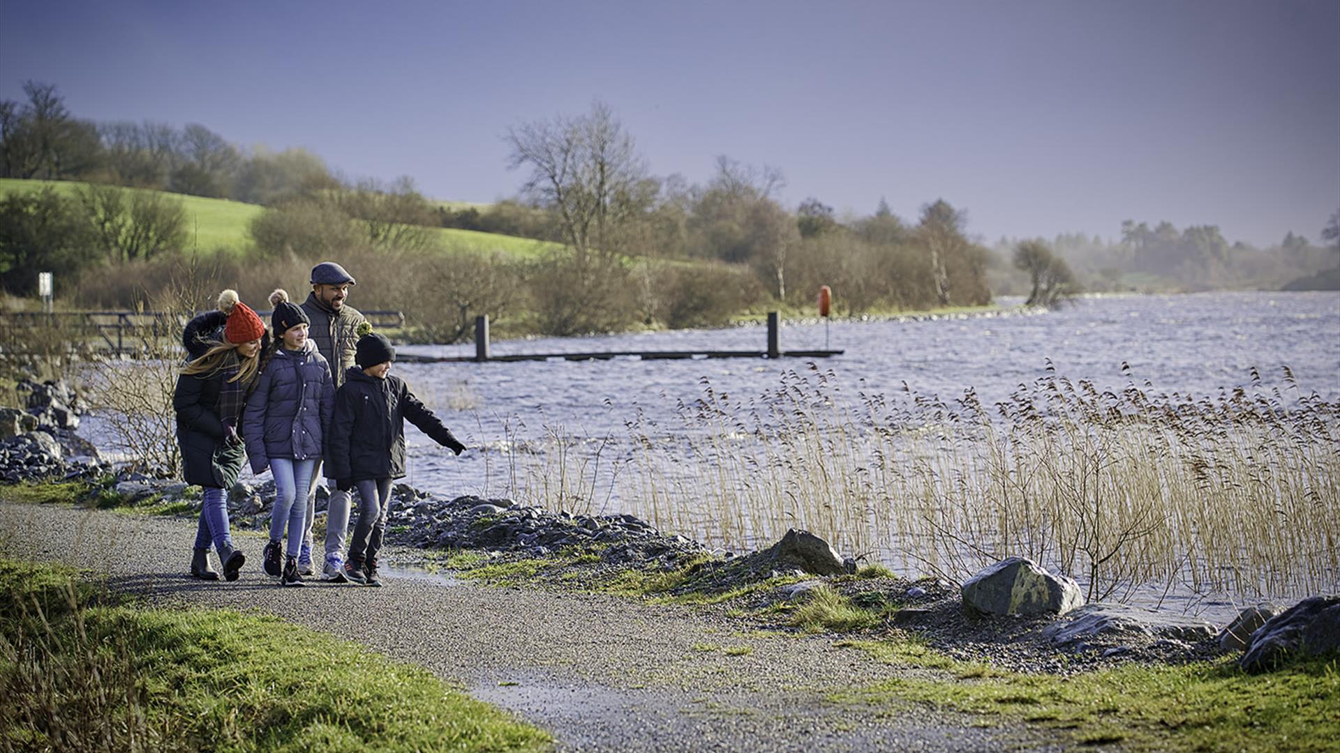 Family walking along the shores of lough Fea.