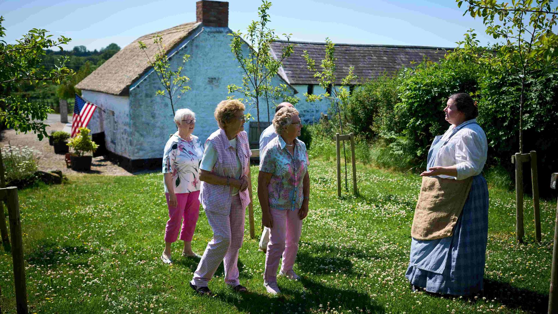 Group of people walking through garden at Arthur Cottage