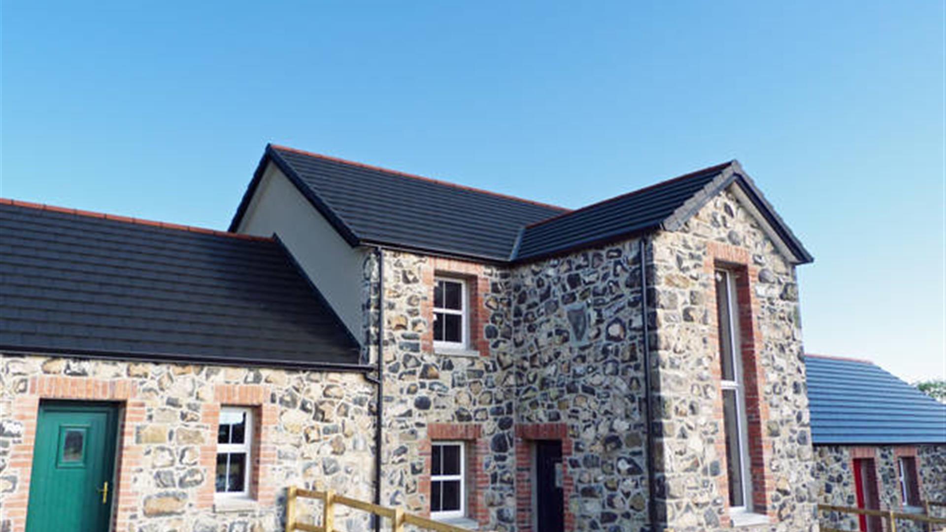 Front exterior view of stone cottages.