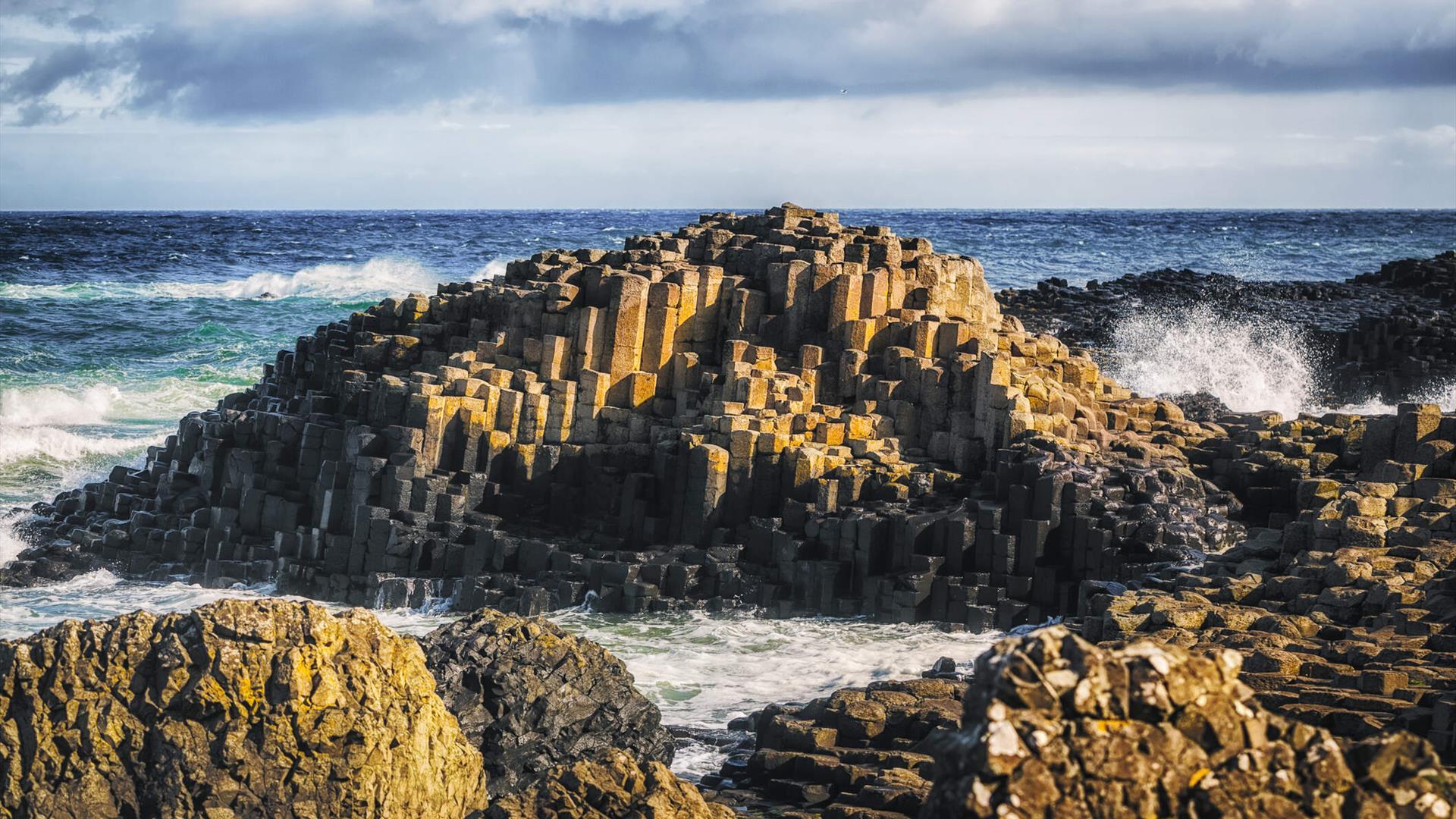 Waves crash against the stones of the Giants Causeway