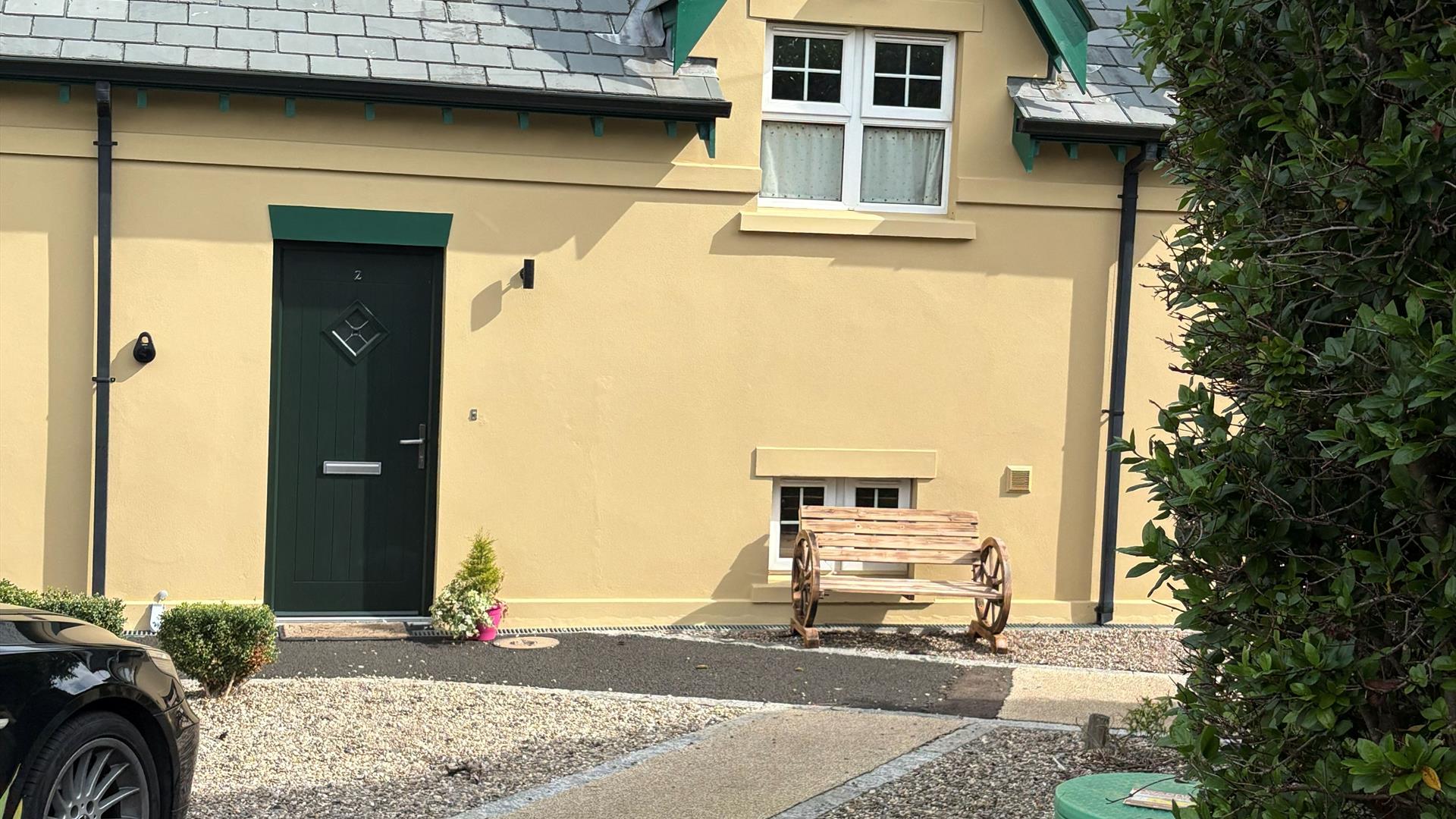 Photograph of front of The Distillers View, bench and plant
