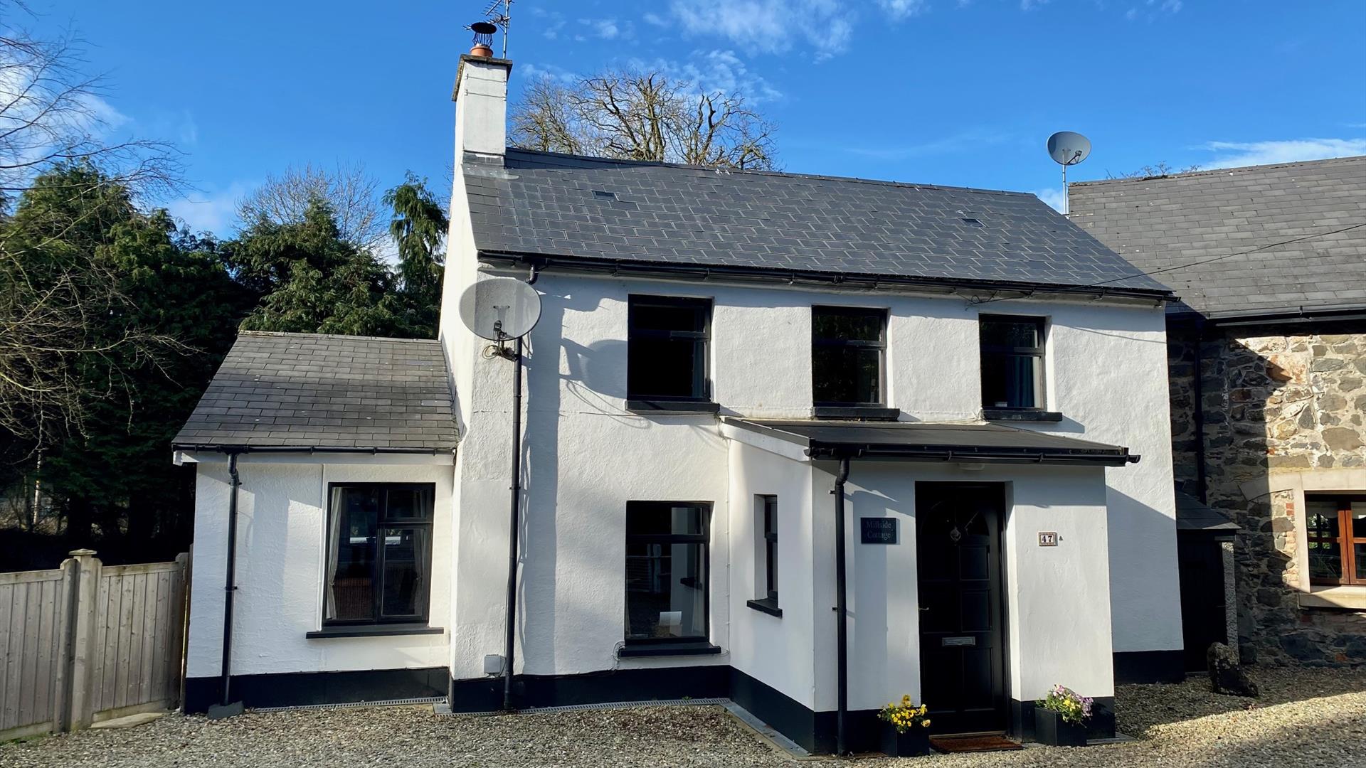 Photo of front of cottage showing position next to the attached old mill