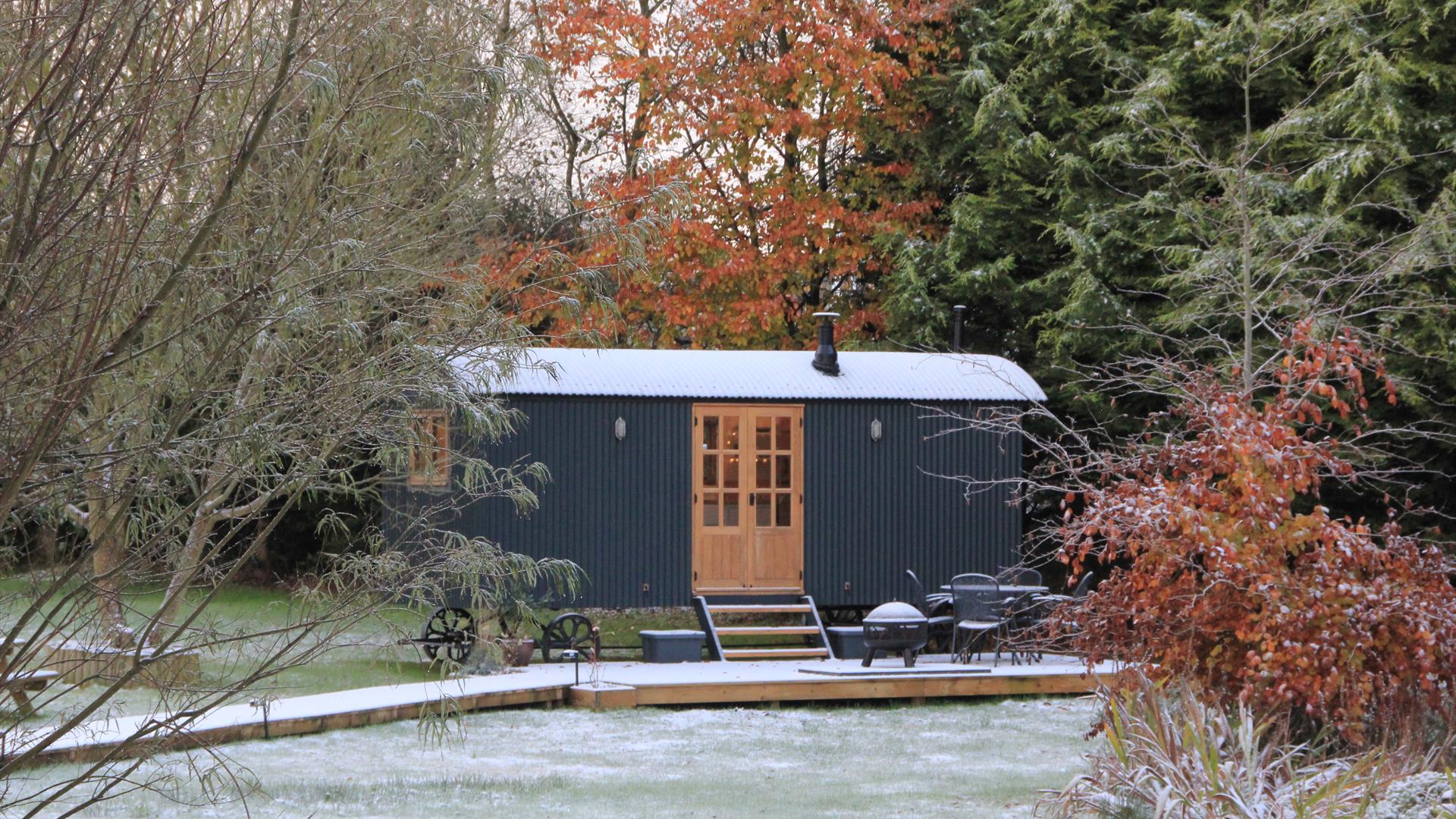 Curlew Hut after a light snow, with beech trees in autumn colour