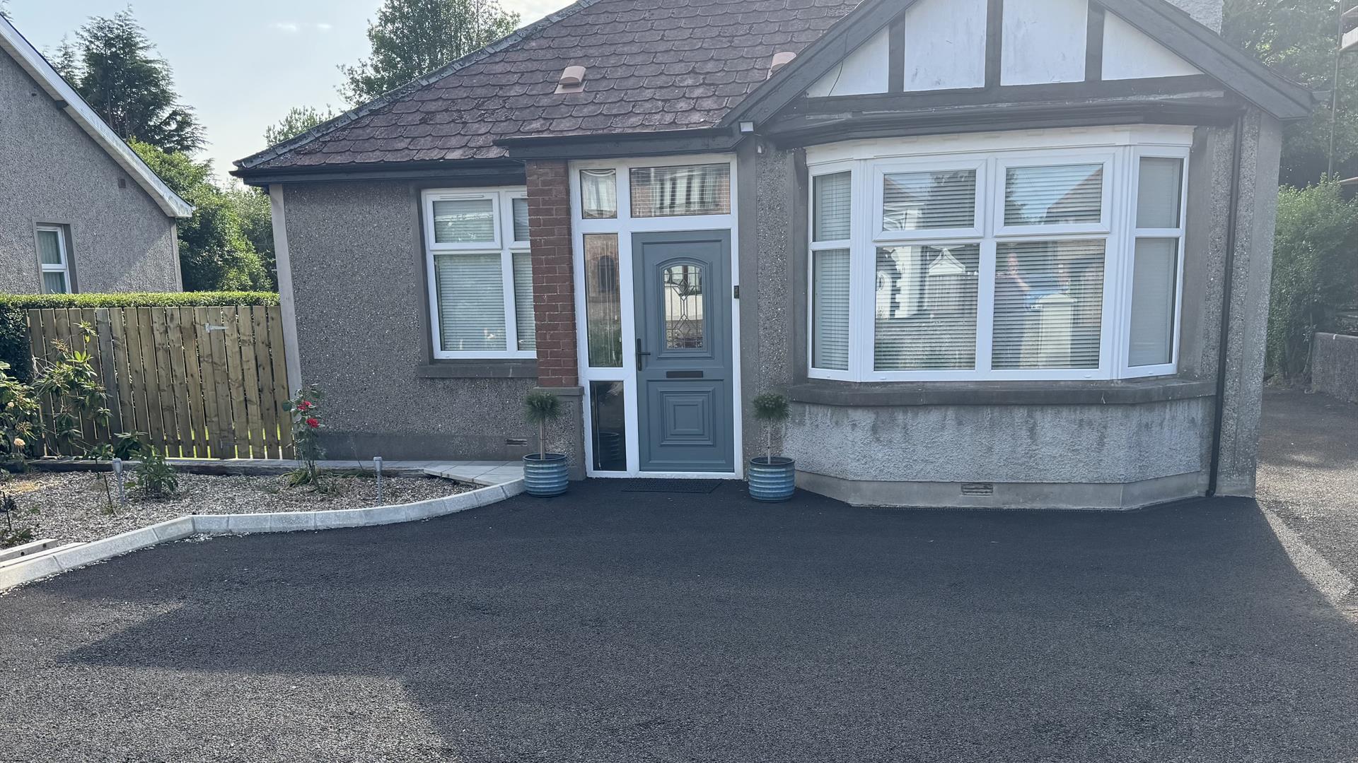 Detached bungalow with red hipped roof and private parking area and garden to front