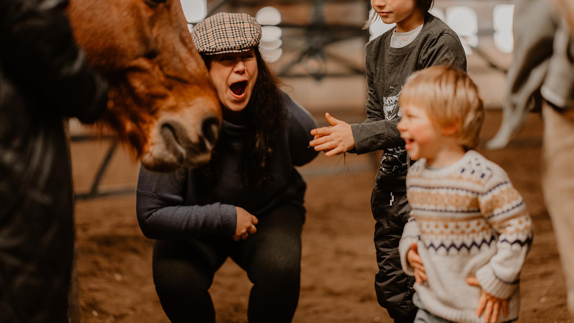 a family laughs and smiles around a horse