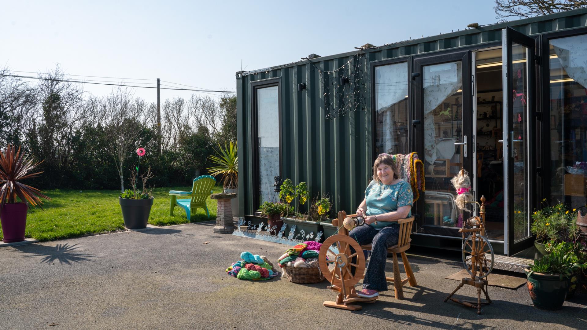 Christine using the spinning wheel outside of the Kiri Cottage Crafts workshop