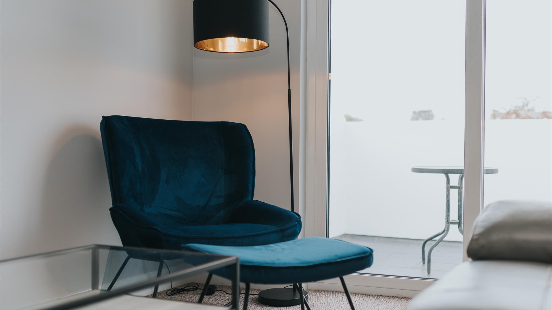 Lounge chair and lamp beside patio window