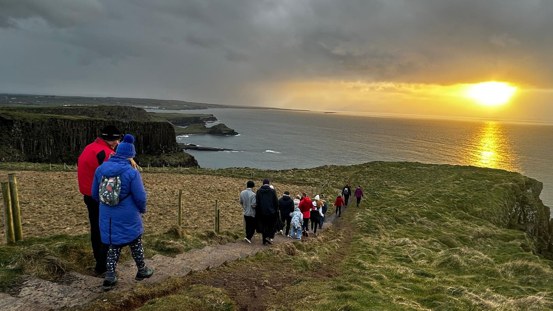 Visitors admiring the sunrise on the Causeway cliffs