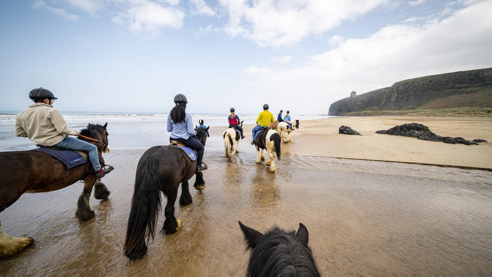 a group of people on horseback on Downhill Beach