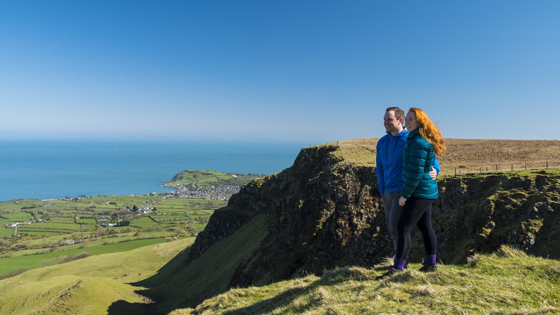 Walkers looking over cliff top at Sallagh Braes