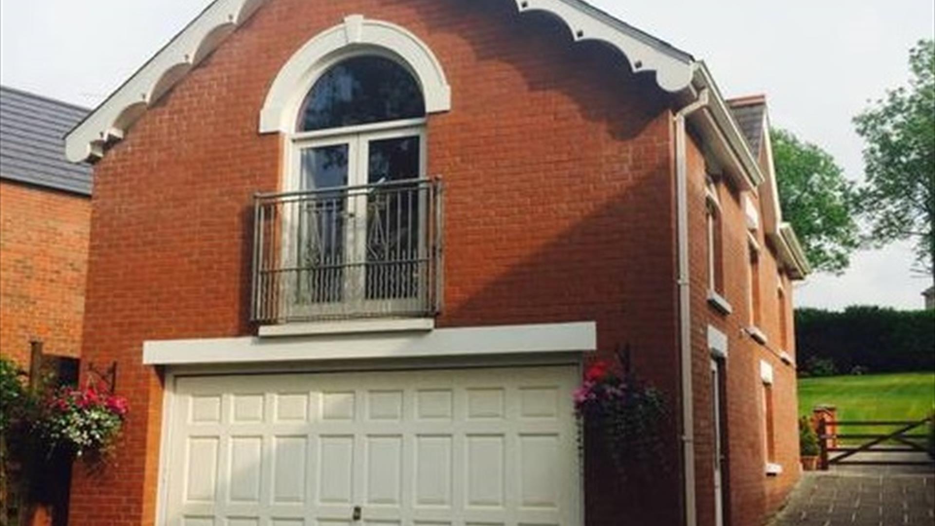 Image shows upstairs apartment patio doors and garage underneath