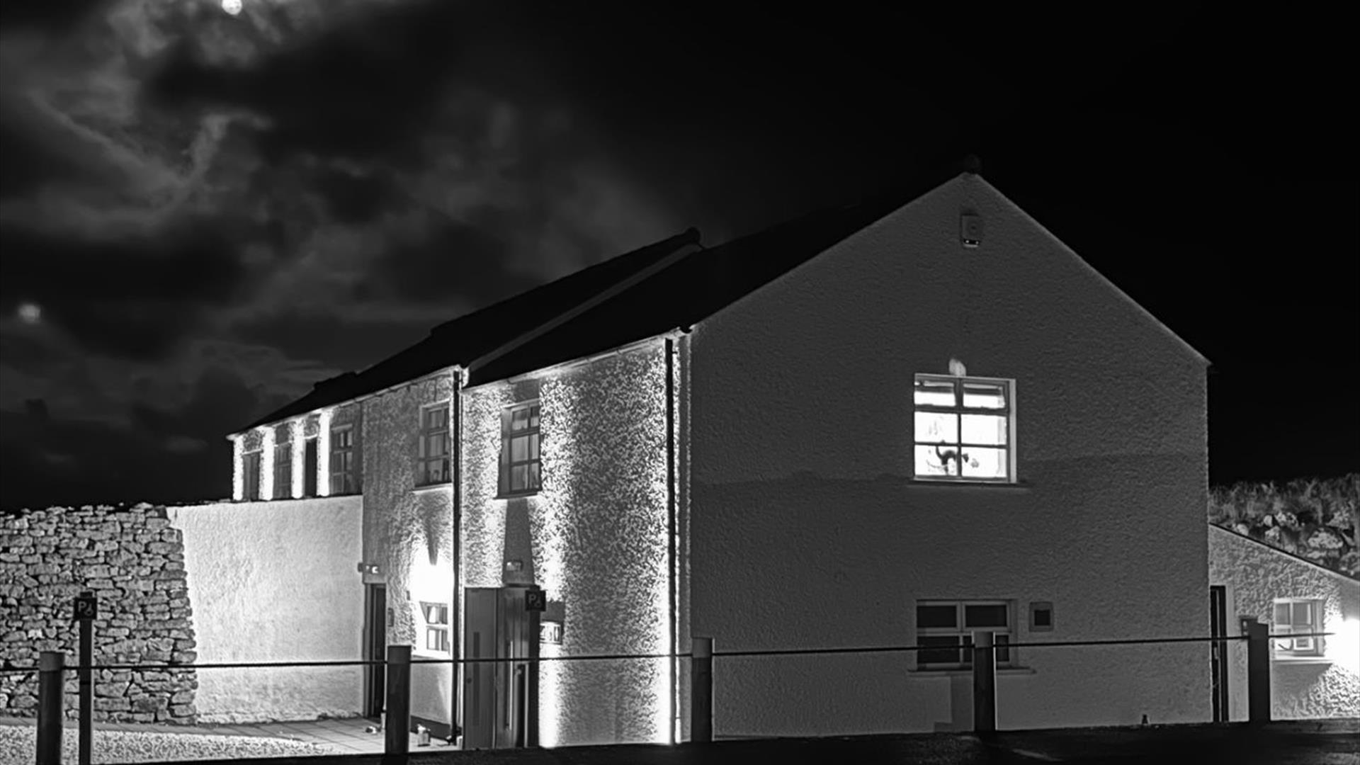 Carrick-a-Rede Tearoom at night with the moon in the background