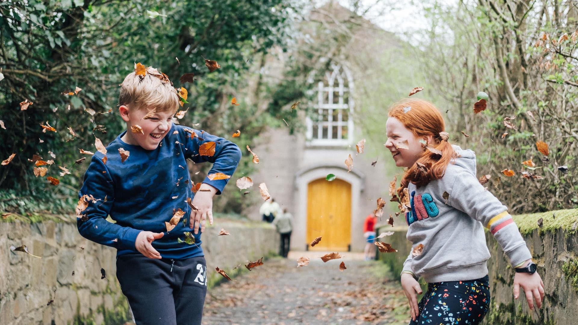 Children enjoying the autumn leaves in the museum grounds