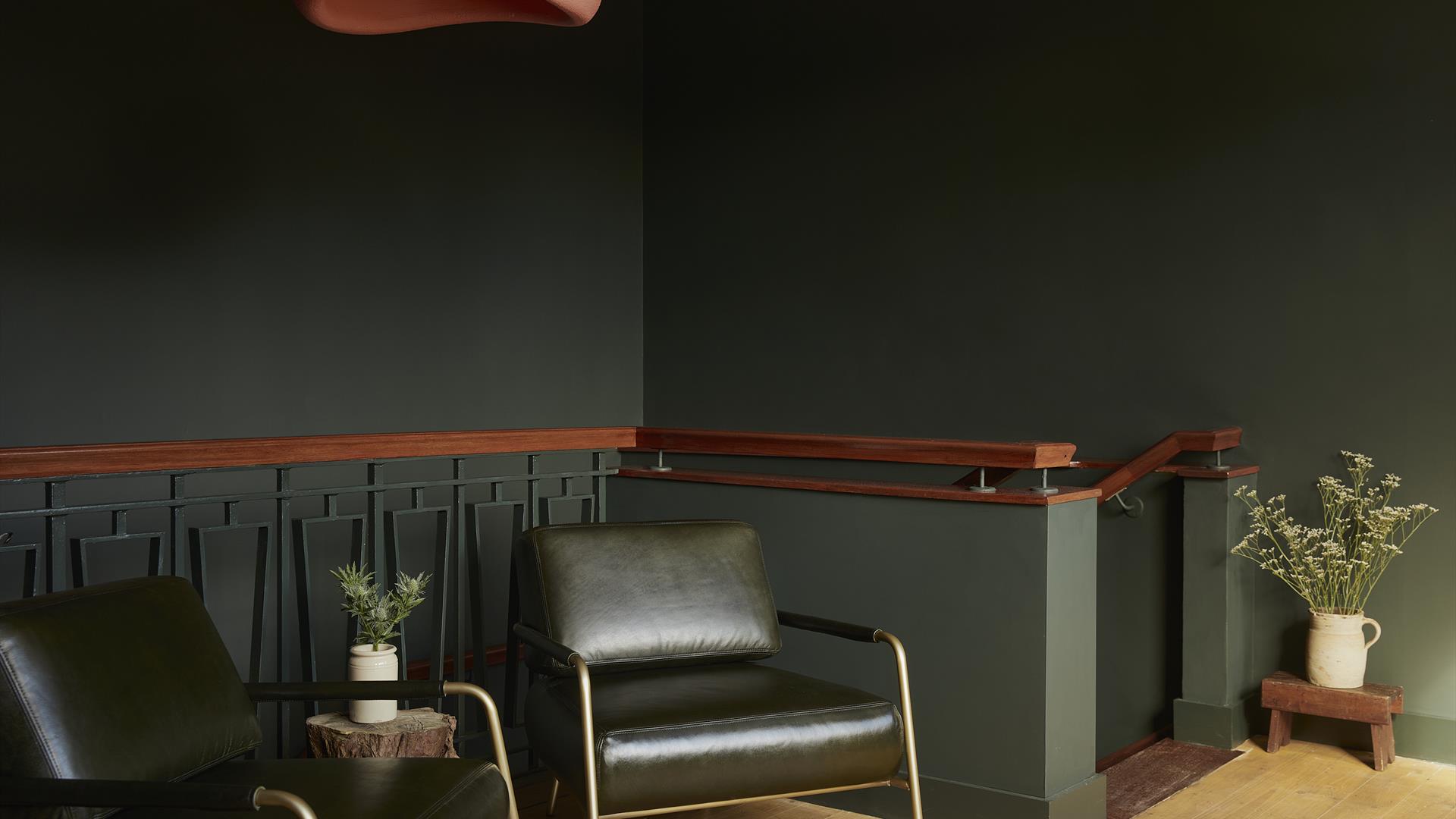 interior of Yarn: 2 lounge chairs and walls painted a dark green