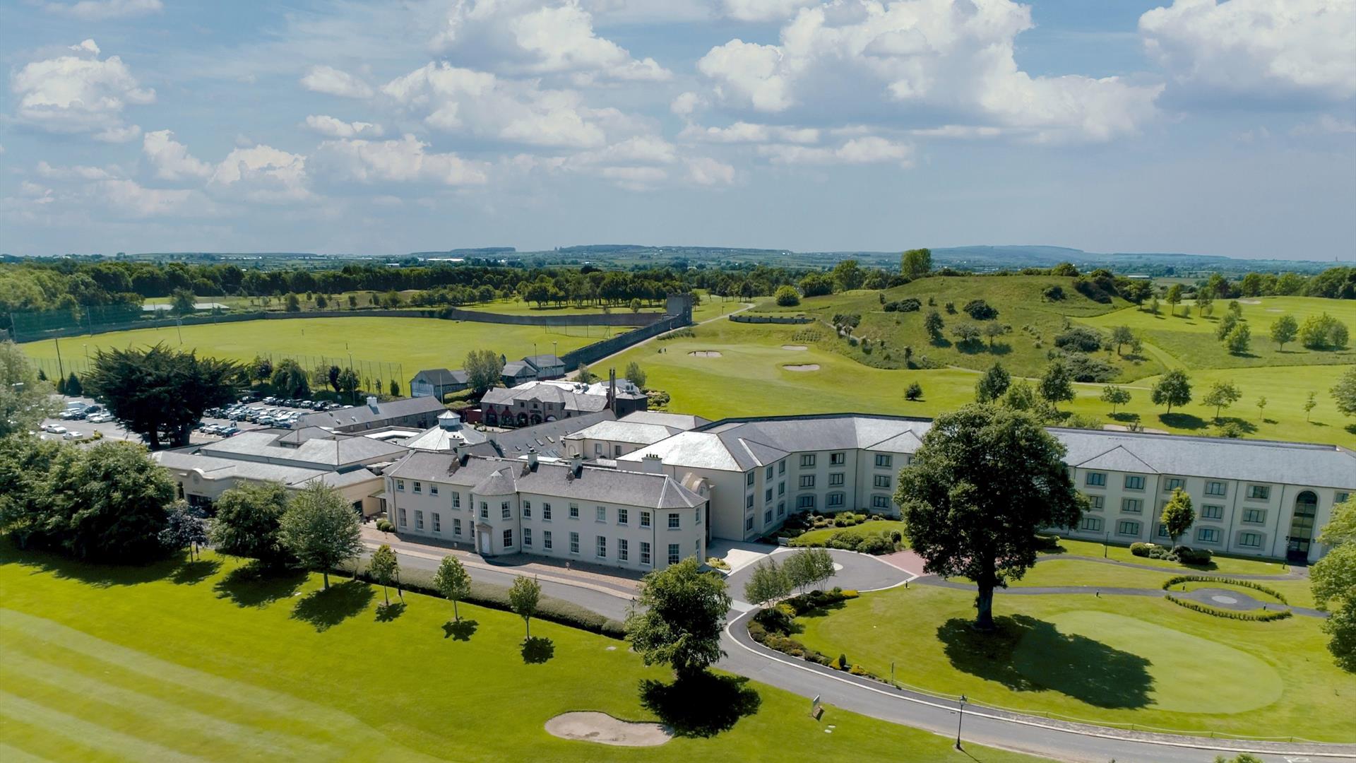 Drone view of the exterior at Roe Park Resort, fluorescent green natural surroundings and golf course.