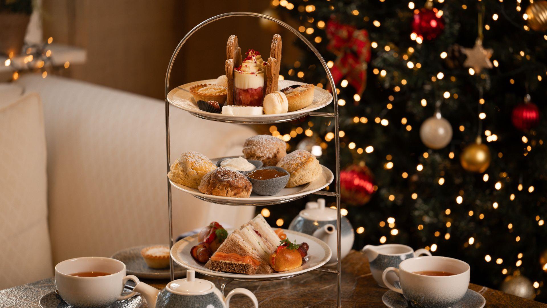 Festive afternoon tea set up with christmas tree in background