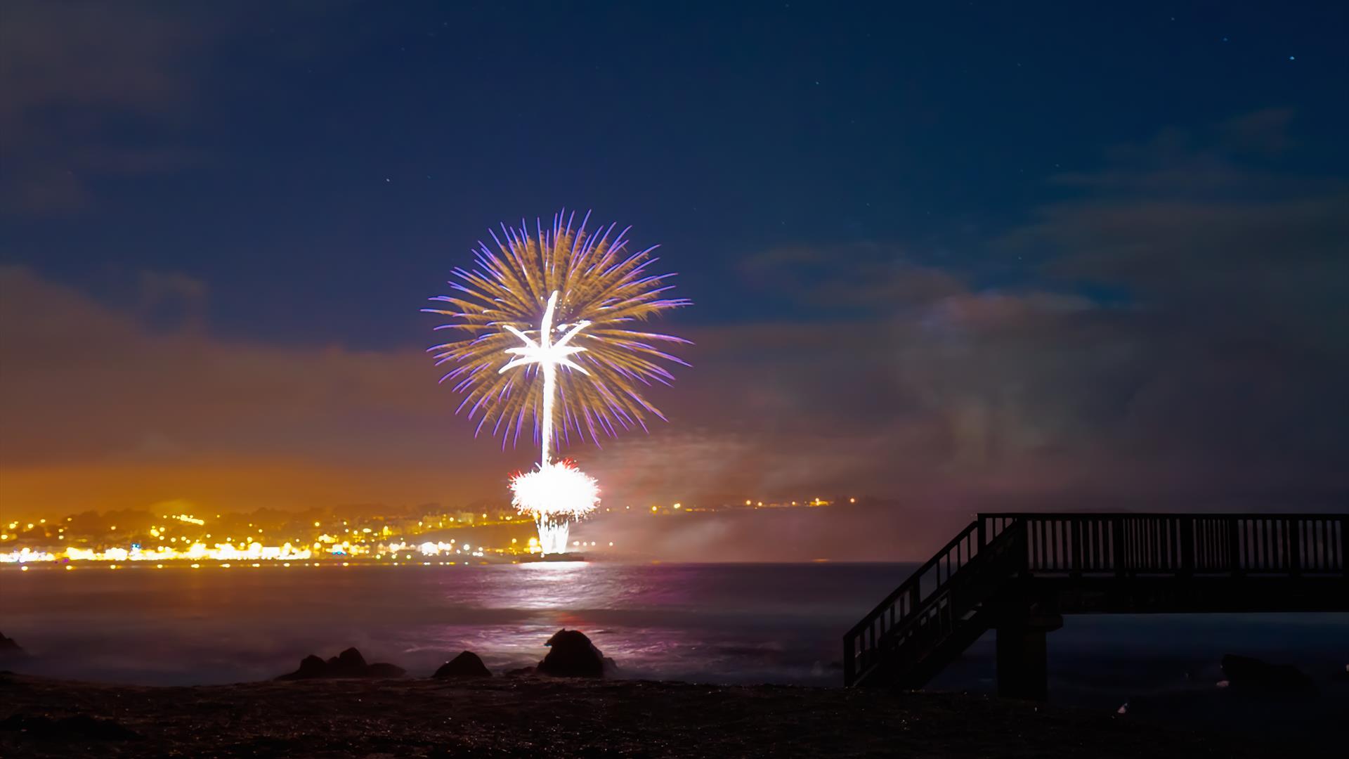 Image shows fireworks lighting up the sky above Ballycastle Beach