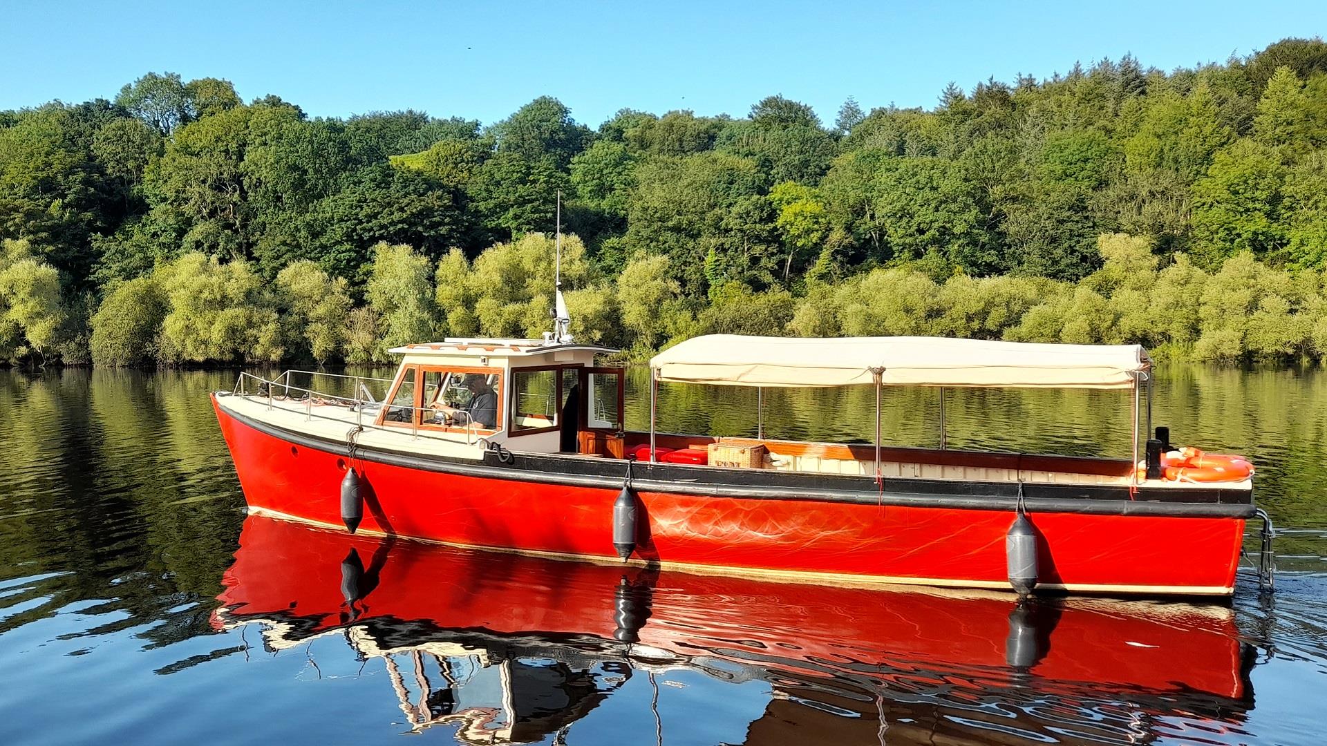 MV Kingfisher boat on the river with Mountsande in  background.