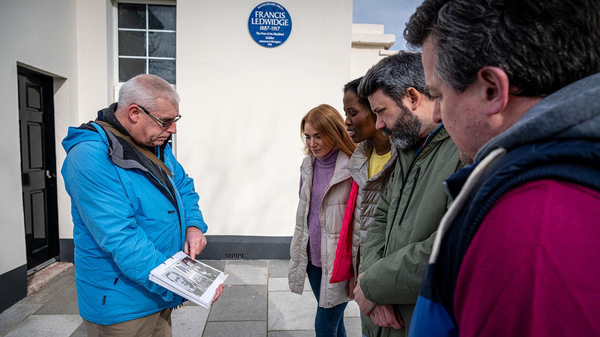 Guide David from Derrie Danders showing a group some literature from his tour