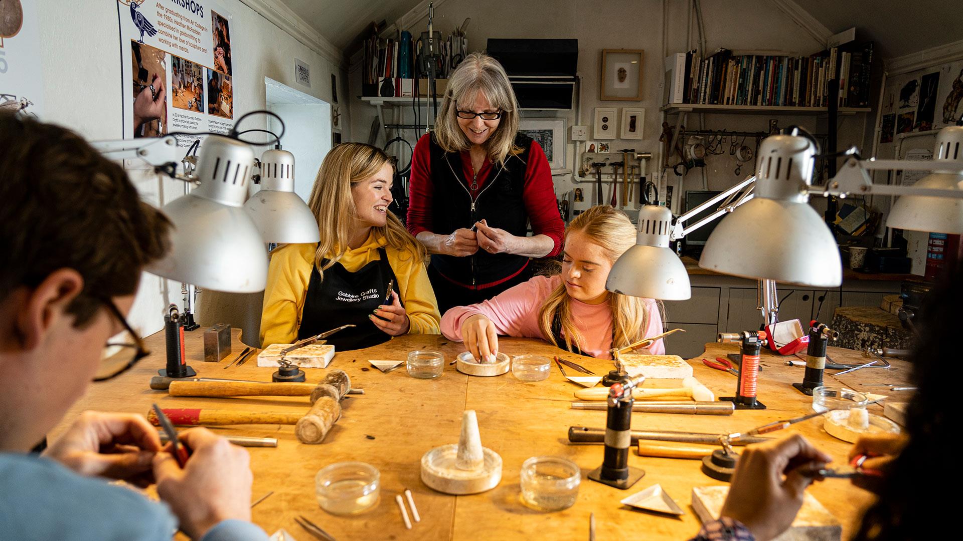 Instructor watching over the group as they make jewellery as part of the workshop with Gobbins Craft in Islandmagee