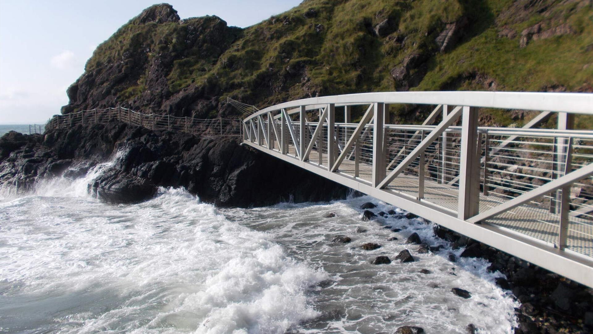 metal walk bridge over the sea linking to the cliff side 