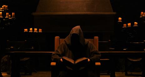 Hooded figure storyteller sitting in Winterfell Hall