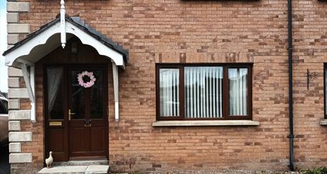 Front exterior of a semi-detached house with a small front lawn.
