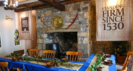 Room set up for Dobbins dining experiece as part of Dobbins Dander and Dine with seats and long tables in front of a large fireplace.