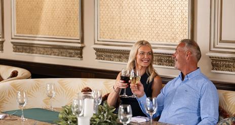 Female and male holding wine glasses at a table in The Gallery of The Old inn