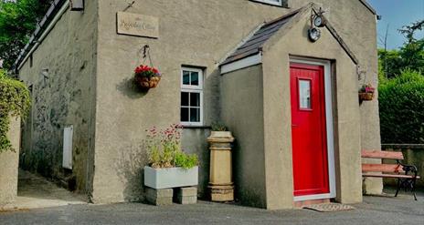 Exterior of cottage with summer seat