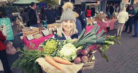 Image of Ashleigh from Cherry Valley Farm - a vegetable farm with market goings-on in the background