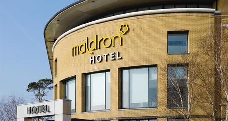 A view of the top rounded wall and sign of the Maldron hotel at Belfast international airport.