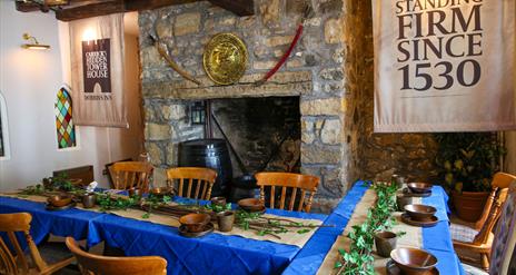 Room set up for Dobbins dining experiece as part of Dobbins Dander and Dine with seats and long tables in front of a large fireplace.